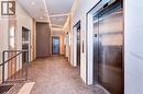 Elevator lobby featuring multiple stainless steel elevator doors, recessed ceiling lighting, wall-mounted sconces, and wood-finish wall panels - 60 Frederick Street Unit# 1213, Kitchener, ON 