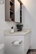 Floating vanity with an integrated sink, polished chrome faucet, and coordinating wall-mounted medicine cabinet with sliding mirrored doors - 
