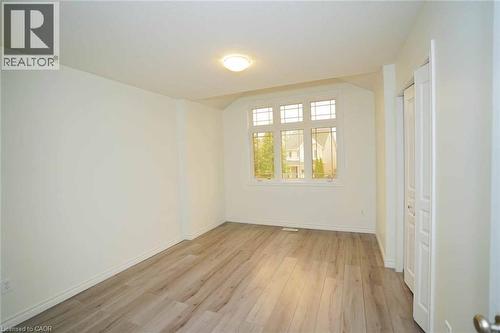 Wood-finish flooring, bay window with multiple panes, ceiling-mounted light fixture, and bifold closet doors - 18 Heritage Drive, Guelph, ON 