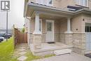 Brick facade with stone accents, covered front porch, decorative entry door, and a paver driveway - 18 Heritage Drive, Guelph, ON 