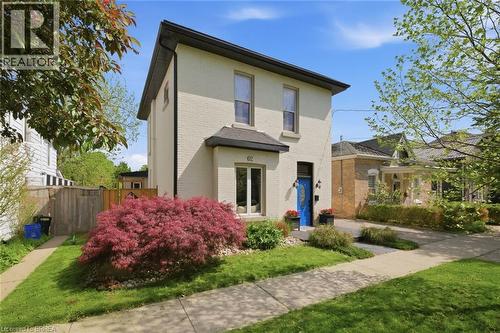 Two-story residence featuring light-colored brick masonry and a contrasting dark roofline - 62 East Avenue, Brantford, ON 