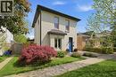 Two-story residence featuring light-colored brick masonry and a contrasting dark roofline - 62 East Avenue, Brantford, ON 