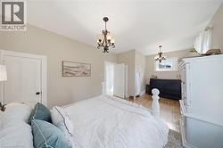 Hardwood flooring extends throughout this space featuring light-toned walls and crown molding - 