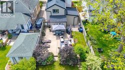 Expansive backyard featuring a large concrete patio, mature trees, and a spacious lawn area - 