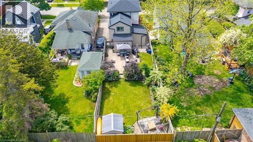 Spacious backyard featuring a manicured lawn, established trees, and a detached shed - 62 East Avenue, Brantford, ON 