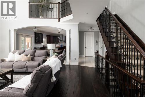 Dark wood-finish flooring throughout, wrought iron balusters, arched entryway, and recessed lighting - 1505 Milburough Line, Carlisle, ON 