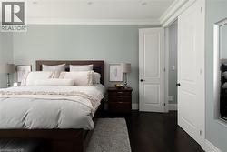 Dark wood-finish flooring, recessed ceiling lighting, crown molding, and paneled doors - 