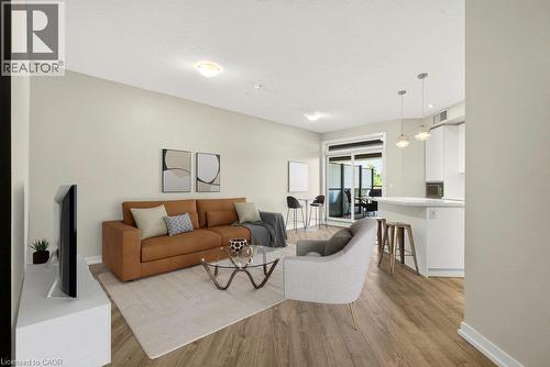 Open-concept living area featuring wood-finish flooring, recessed lighting, and a neutral color palette - 457 Plains Road Unit# 225, Burlington, ON 