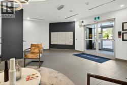 Lobby entrance featuring large format tile flooring, a wall of individual mailboxes, and double glass-paneled doors with aluminum frames - 