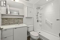 Modern bathroom featuring a walk-in shower with white subway tile, an integrated shower system, and built-in shelving - 
