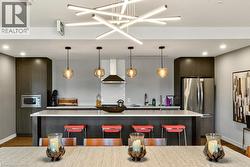 Kitchen featuring dark wood-finish cabinetry, stainless steel appliances, and a central island with white countertops - 