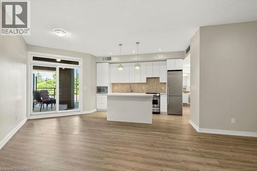 Open-concept living space featuring wood-finish flooring and light-toned walls - 457 Plains Road Unit# 225, Burlington, ON 