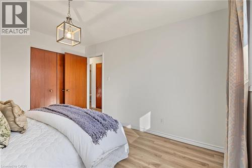 PRIMARY BEDROOM with NEW vinyl flooring, large closet, vinyl window & elegant New light fixture. - 589 Mohawk Road W, Hamilton, ON 