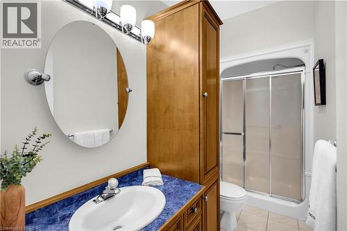 Bathroom vanity with an oval mirror and chrome lighting fixture - 302 German School Road, Paris, ON 