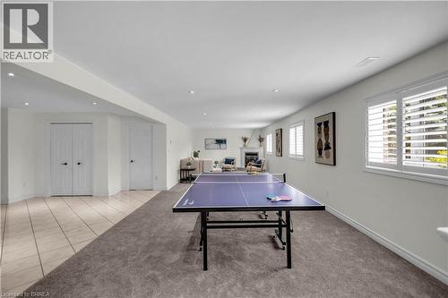 Spacious room featuring recessed lighting, multiple windows with white plantation shutters, and a partial carpet flooring - 302 German School Road, Paris, ON 