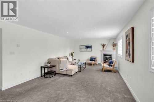 Living space featuring a corner fireplace with white mantel, recessed lighting, and carpet flooring - 302 German School Road, Paris, ON 