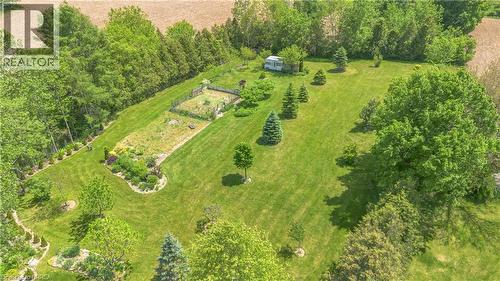 Expansive green space featuring mature trees, manicured lawns, and established garden beds - 302 German School Road, Paris, ON 