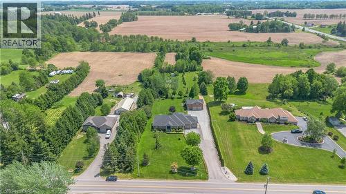 Expansive rural property featuring three distinct residences, a paved driveway, and mature landscaping - 302 German School Road, Paris, ON 