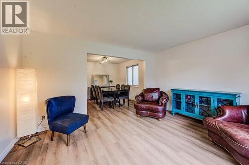 Light wood-finish flooring throughout, white painted walls, and an open archway to an adjacent room - 143 Sunrise Place, Kitchener, ON 