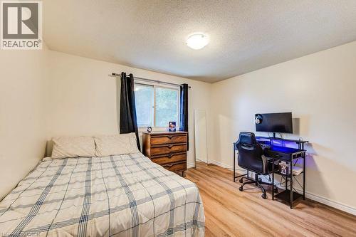 Neutral wall paint, wood-finish flooring, a window with dark curtains, and a ceiling-mounted light fixture - 143 Sunrise Place, Kitchener, ON 