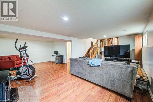 Expansive open area featuring wood-finish flooring, recessed lighting, and a visible staircase - 143 Sunrise Place, Kitchener, ON 