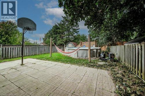 Expansive backyard featuring a patterned paver patio, a basketball hoop, an above-ground pool, and a storage shed - 143 Sunrise Place, Kitchener, ON 