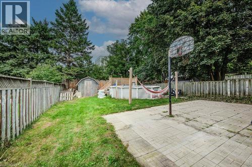 Grassed yard area, wood fencing, concrete patio area, mature trees, wood shed - 143 Sunrise Place, Kitchener, ON 