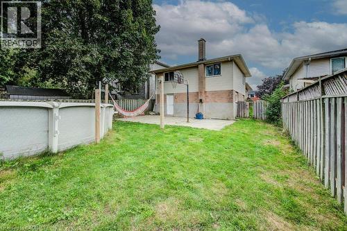 Expansive grassy yard with an above-ground pool, concrete patio, and fenced perimeter - 143 Sunrise Place, Kitchener, ON 