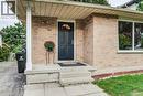 Brick exterior with a covered entryway, front door with an arched window, and a large front window - 143 Sunrise Place, Kitchener, ON 