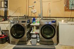 Dedicated laundry area featuring a utility sink and concrete flooring - 