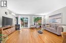 Hardwood flooring, wood-burning stove, sliding glass door, window, and wall-mounted air conditioning unit - 1517 Elm Road Unit# 9, Oakville, ON 