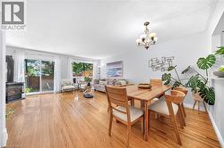 Hardwood-finish flooring throughout, multiple large windows, and a sliding glass door - 