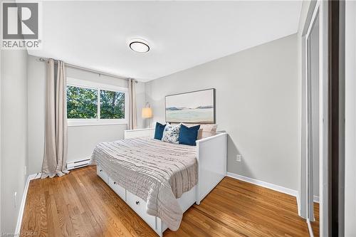 Hardwood flooring, painted walls, white trim, sliding window, and a built-in storage unit - 1517 Elm Road Unit# 9, Oakville, ON 