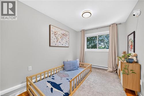 Neutral wall color, window with natural lighting, ceiling-mounted light fixture, carpeting, and wood-finish flooring - 1517 Elm Road Unit# 9, Oakville, ON 