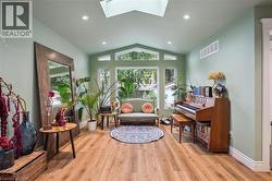 Vaulted ceiling with skylight, recessed lighting, carpet-free floor, and expansive windows - 