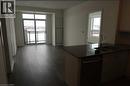 Kitchen with dishwasher, a peninsula, and dark wood-style flooring - 1105 Leger Way Unit# 329, Milton, ON 