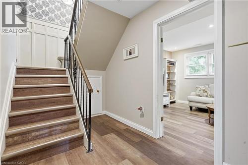 Staircase with wrought iron balustrade, wood-finish treads, and white risers - 72 Crestlynn Crescent, Simcoe, ON 