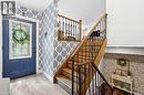 Entryway featuring a blue door with decorative glass, patterned wallpaper, and light-toned tile flooring - 72 Crestlynn Crescent, Simcoe, ON 