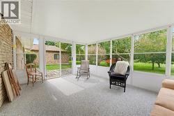 Enclosed sunroom with expansive windows, offering abundant natural light and exterior access - 