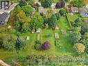Expansive green lawn with mature trees, multiple garden beds, and two outbuildings - 15 Mclaren Avenue N, Listowel, ON 