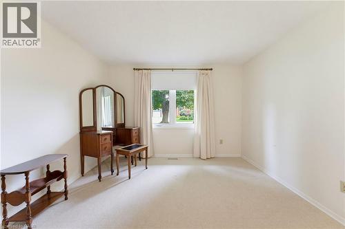 Soft neutral wall tones, window with white trim, and light carpeting throughout - 15 Mclaren Avenue N, Listowel, ON 