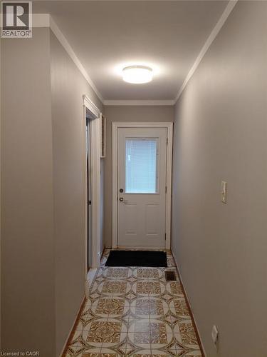 Patterned floor tile with brown and cream tones, crown molding, and a flush mount ceiling light fixture - 244 Guildwood Drive, Hamilton, ON 