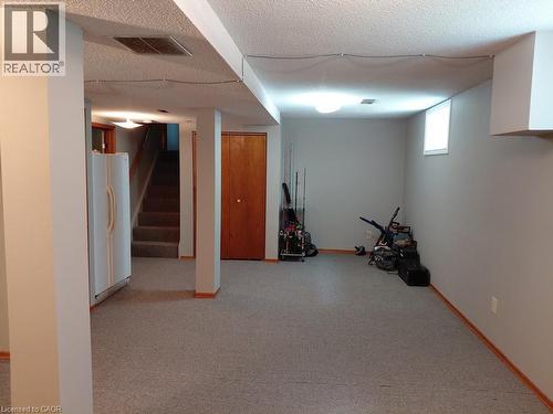 Spacious lower level featuring light gray walls, carpet flooring, a compact window, and a built-in storage closet with wood-finish doors - 244 Guildwood Drive, Hamilton, ON 
