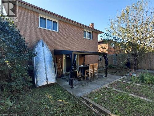 Brick exterior featuring multiple windows and a covered patio area - 244 Guildwood Drive, Hamilton, ON 
