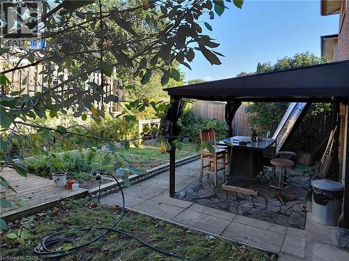Patio area featuring paver stones, a black gazebo, and a raised garden bed - 244 Guildwood Drive, Hamilton, ON 