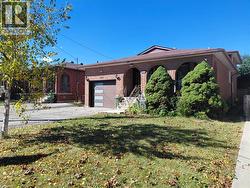Brick exterior with arched window openings, a contemporary garage door, and a front yard with established plantings - 