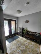 Patterned tile flooring, double entry doors with decorative glass panels, and a flush mount ceiling light fixture - 