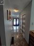 Hallway featuring patterned tile flooring, flush-mount lighting, and bi-fold closet doors with frosted panels - 244 Guildwood Drive, Hamilton, ON 