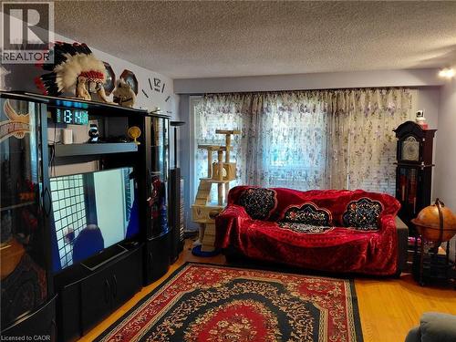 Wood-finish flooring, light purple wall paint, and a textured ceiling - 244 Guildwood Drive, Hamilton, ON 