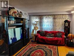 Wood-finish flooring, light purple wall paint, and a textured ceiling - 